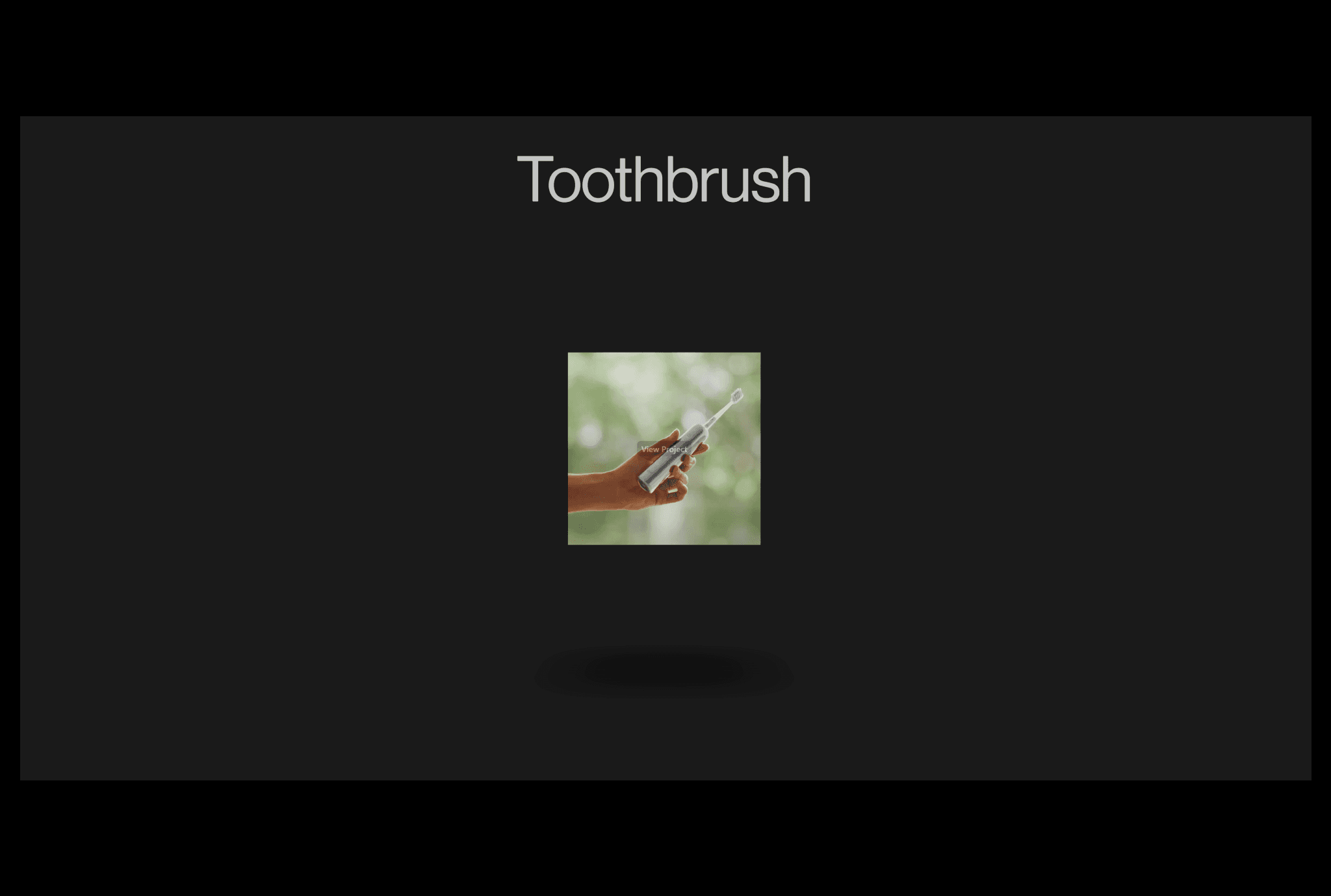 Dark webpage headed Toothbrush, with a central photograph of a hand holding an electric toothbrush above a soft shadow.